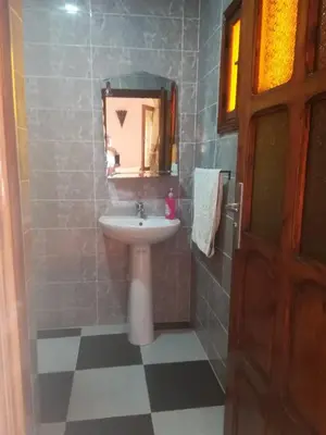 a bathroom with a sink and a mirror at Riad Ouinz in Aït Ben Haddou