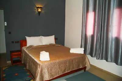 a bedroom with a bed with two towels on it at Riad Ouinz in Aït Ben Haddou