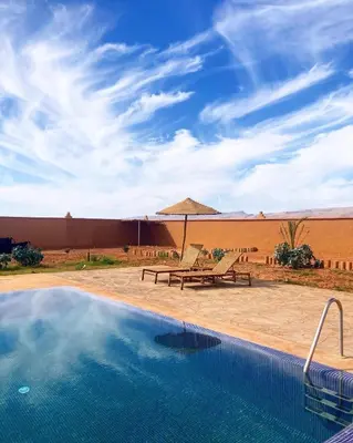 a swimming pool with a picnic table and a picnic bench at Tigmi Timhar in Tafrourht nʼAït Bou Jijou