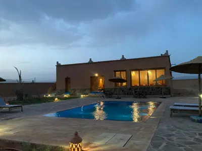 a villa with a swimming pool at night at Tigmi Timhar in Tafrourht nʼAït Bou Jijou