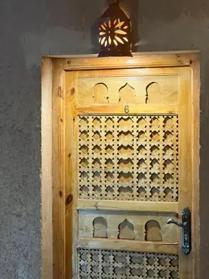 a wooden door with a clock on top of it at Tigmi Timhar in Tafrourht nʼAït Bou Jijou