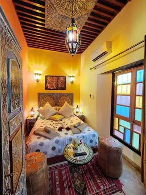 a bedroom with a bed and a table in a room at Riad Dar Kassim in Fès
