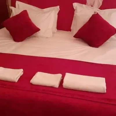 a red and white bed with red and white pillows at Excreción erg chegaga 2 jour départ zagora 4x4 in Zagora