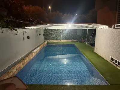 a swimming pool in a backyard at night at Dar el kebira in Meknès