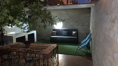 a patio with a couch and a table and chairs at Dar el kebira in Meknès