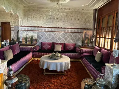 a living room with a purple couch and a table at Dar el kebira in Meknès