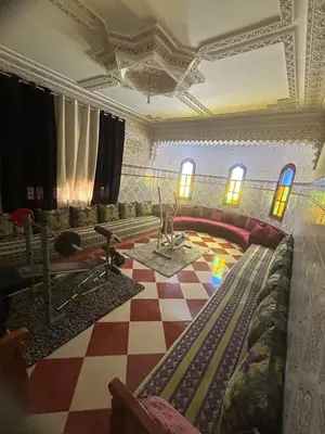 a living room with a couch and a checkered floor at Dar el kebira in Meknès