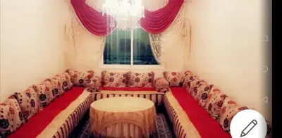 a couch with a table in a room with a window at Home twins fes in Fès