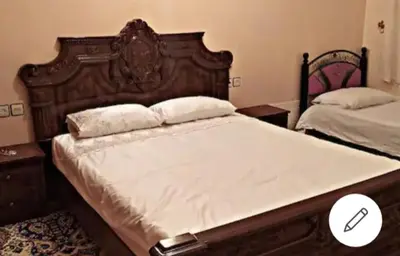 a bedroom with a large bed with a wooden headboard at Home twins fes in Fès