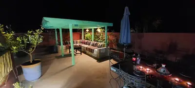 a patio with a couch and a table and umbrella at Riad Ramzi in Marrakech