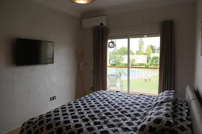 a bedroom with a bed and a large window at Golf Royal appartement in Fès
