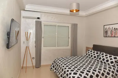 a bedroom with a bed and a window at Golf Royal appartement in Fès