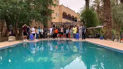 a group of people standing next to a swimming pool at Gite D'Etape Amced in Goulmima