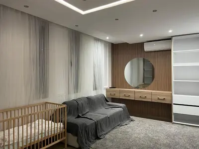 a bedroom with a crib and a mirror at Magnifique Villa in Beni Mellal