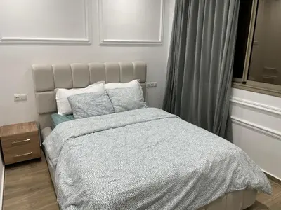 a bedroom with a bed with a white comforter and pillows at Magnifique Villa in Beni Mellal
