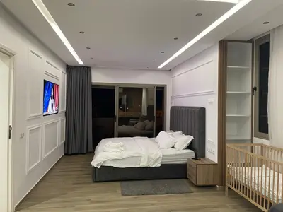 a bedroom with a bed and a crib in it at Magnifique Villa in Beni Mellal