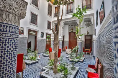 a courtyard with a tree in the middle of a building at Riad Dari Fes in Fès