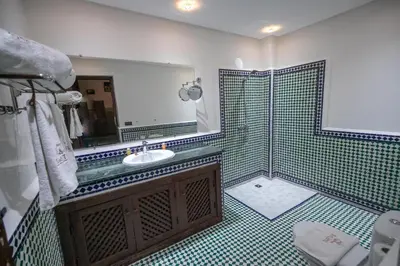 a bathroom with a sink and a shower with a mirror at Riad Dari Fes in Fès