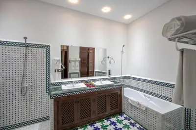 a bathroom with a tub and a sink and a mirror at Riad Dari Fes in Fès