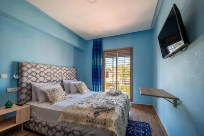 a blue bedroom with a bed and a window at Riad Les Nuits De Fès in Fès