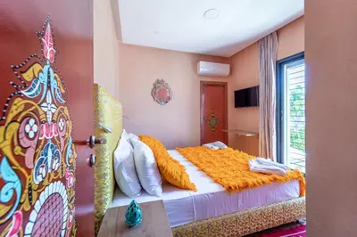 a bedroom with a large bed with an orange blanket at Riad Les Nuits De Fès in Fès