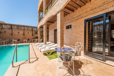 a patio with a table and chairs next to a pool at Riad Les Nuits De Fès in Fès