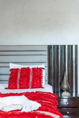 a bedroom with a red bed with red pillows at Riad Les Nuits De Fès in Fès