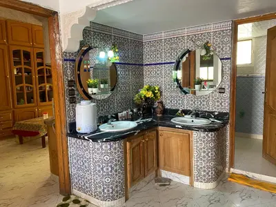 a bathroom with two sinks and a large mirror at Appartement Villa Rayhana in Khenifra