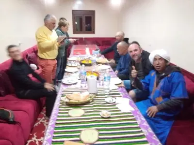 a group of people sitting around a long table at Auberge Chez Bassou Agoudal in Agoudal