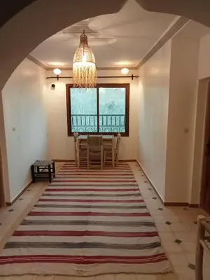 a dining room with a table and chairs and a chandelier at Auberge Kasbah Ait Marghad in Tamellalt
