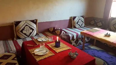 a room with a table with a candle on it at Auberge Kasbah Ait Marghad in Tamellalt