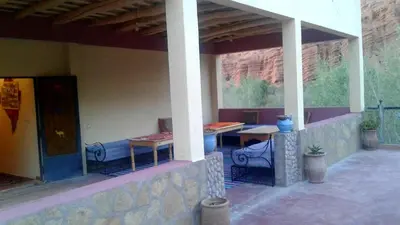 a patio with two tables and chairs on a building at Auberge Kasbah Ait Marghad in Tamellalt