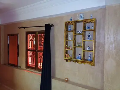 a wall with a shelf with vases and a window at Riad Heermans in Ouzoud