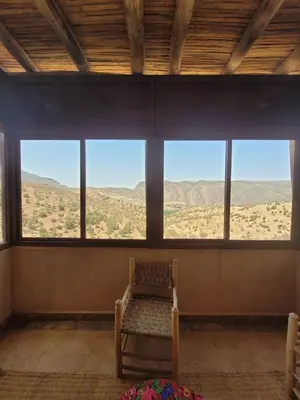 a room with a bench in a room with windows at Riad Heermans in Ouzoud