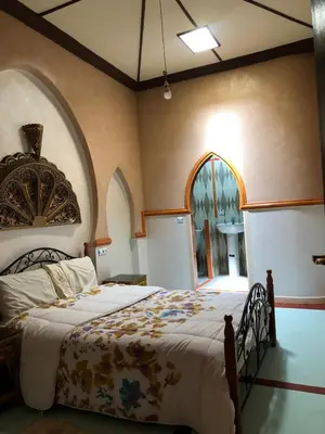 a bedroom with a bed and an arched window at Hotel Restaurant Hollywood Africa in Aït Ben Haddou