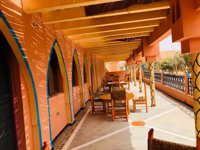 a patio with tables and chairs on a building at Hotel Restaurant Hollywood Africa in Aït Ben Haddou
