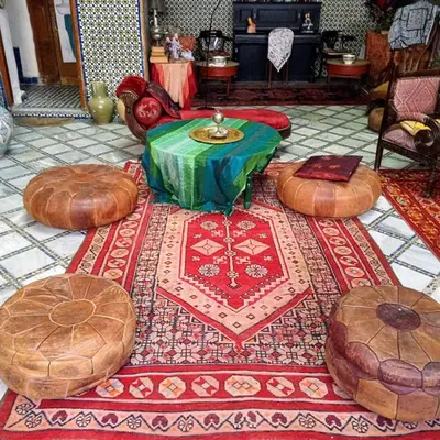 a group of ottoman tables and chairs on a floor at Riad Rchacha in Fès