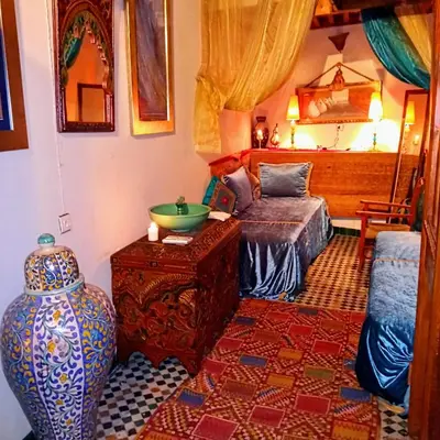 a living room with a vase and a bed at Riad Rchacha in Fès