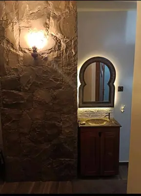 a bathroom with a sink and a stone wall at Harmony in Azrou