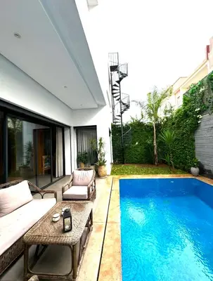 a backyard with a pool and a couch and a table at Moon house in Ville Nouvelle