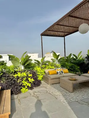 a patio with couches and flowers and the ocean at Moon house in Ville Nouvelle