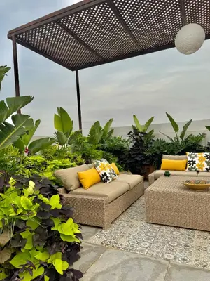 a patio with couches and plants and a large umbrella at Moon house in Ville Nouvelle