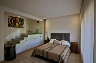 a bedroom with a bed and a staircase in it at Moon house in Ville Nouvelle