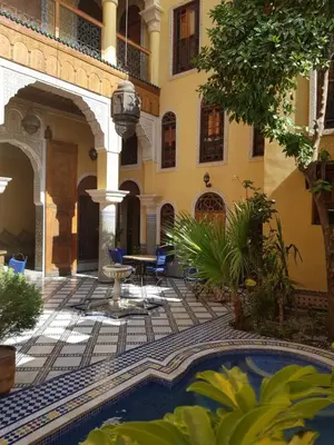 a courtyard with a pool in front of a building at Riad Layalina Fes 7 Chambres & 18 Personnes Piscine, Parking, Vue & Wifi au Pied Medina in Fès