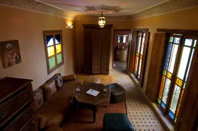 a living room with a couch and a table at Riad Layalina Fes 7 Chambres & 18 Personnes Piscine, Parking, Vue & Wifi au Pied Medina in Fès