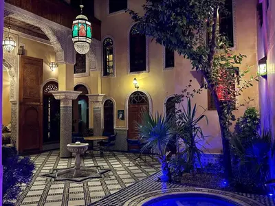 a building with a courtyard with a pool in the middle at Riad Layalina Fes 7 Chambres & 18 Personnes Piscine, Parking, Vue & Wifi au Pied Medina in Fès