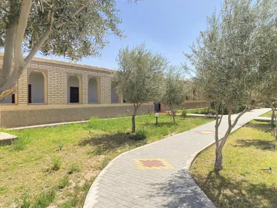 a brick walkway in front of a building with trees at IGHIZ INN resort in Er Rachidia