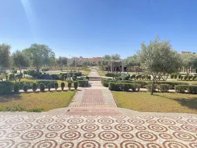 a pathway in a park with trees and bushes at IGHIZ INN resort in Er Rachidia