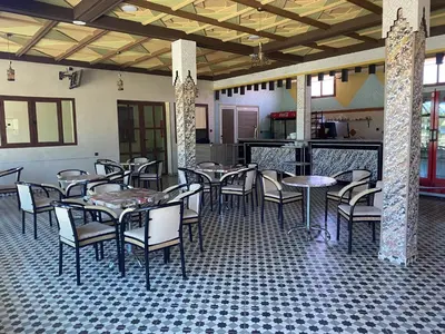 a restaurant with tables and chairs in a room at IGHIZ INN resort in Er Rachidia