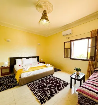 a bedroom with a bed and a window and a couch at Guest House Qodwa in Marrakech